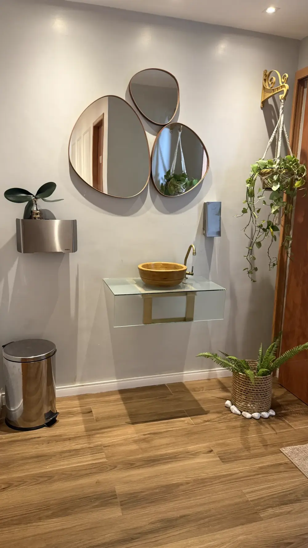 Lavabo do Espaço Raygus com bancada de vidro, cuba de madeira e espelhos