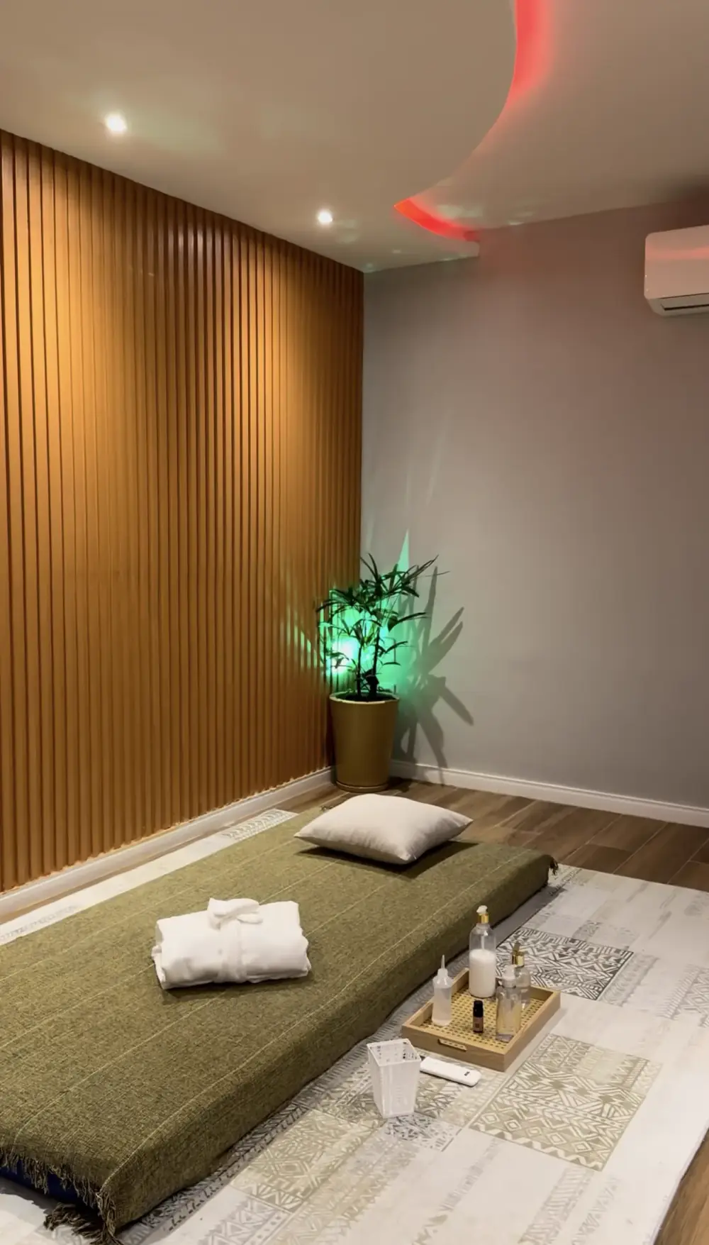 Sala de atendimento com parede ripada de madeira e futon no piso